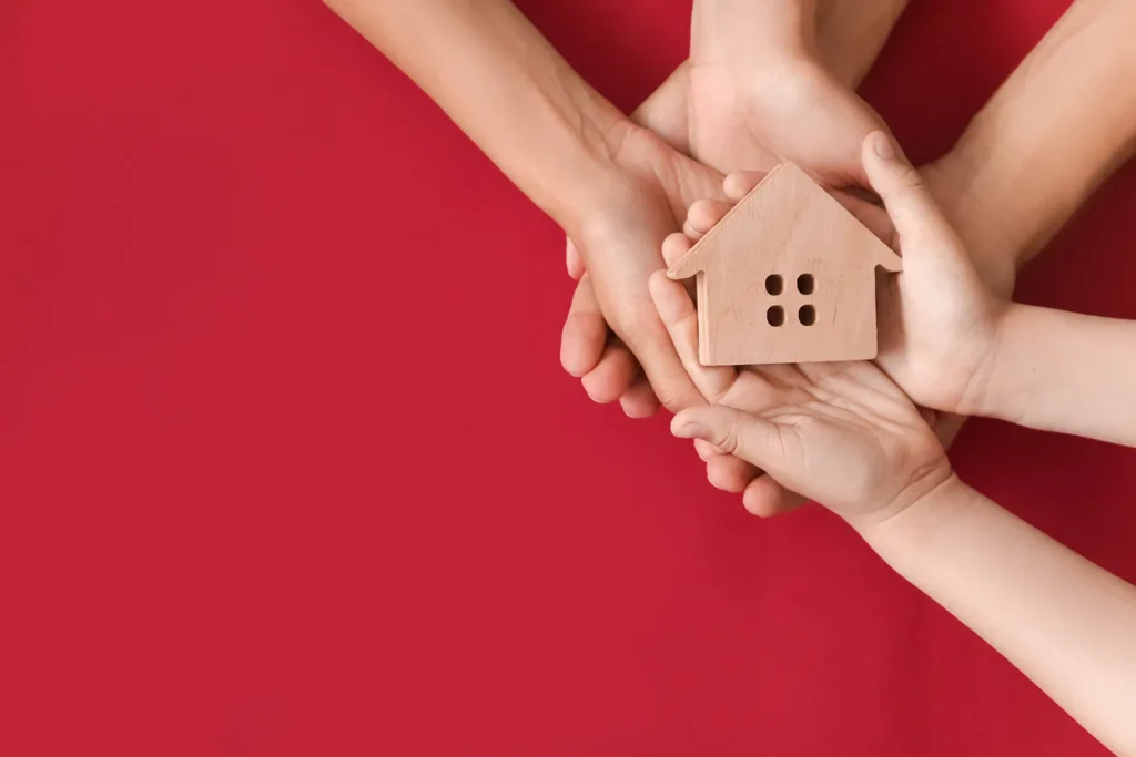 A wooden model house on a red background